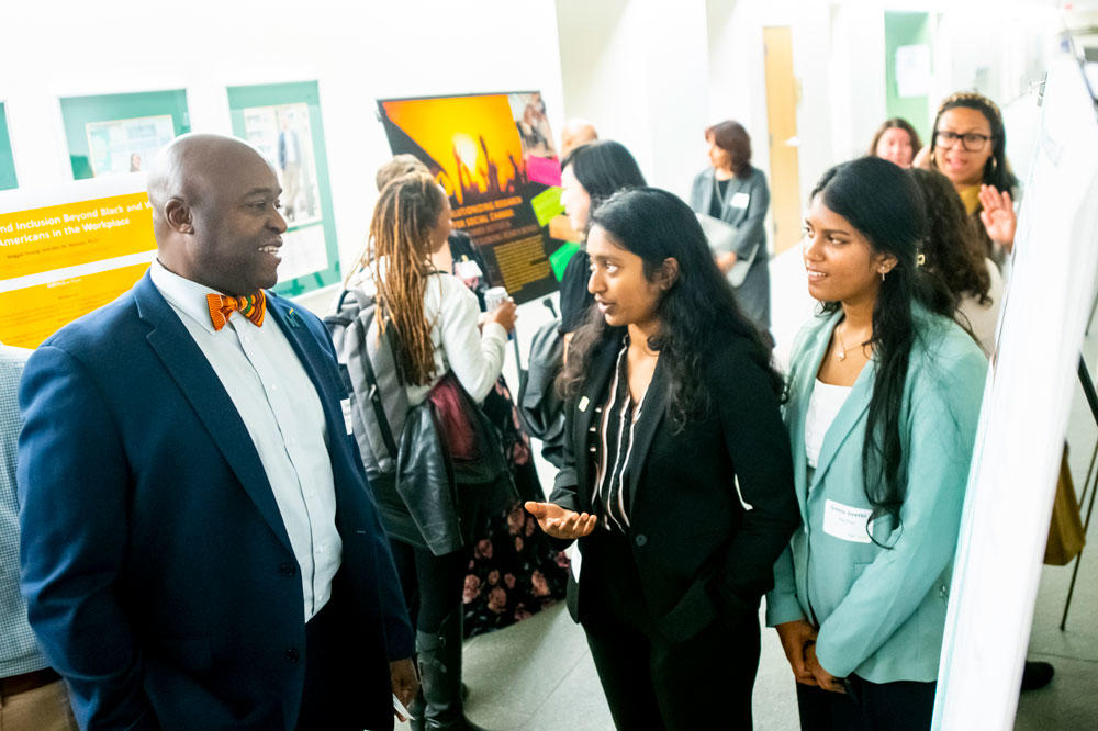 Researchers discuss their poster projects with President Gregory Washington at the ARIE National Conference